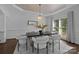 Bright dining room with hardwood floors, decorative ceiling, modern chandelier and large windows at 5303 Shasta Hill Ct, Charlotte, NC 28211