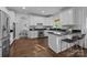 Well-lit kitchen with white cabinets, dark countertops, stainless steel appliances, and breakfast bar seating at 5303 Shasta Hill Ct, Charlotte, NC 28211