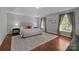 Calm main bedroom with tray ceiling, neutral paint, large windows, and hardwood floors at 5303 Shasta Hill Ct, Charlotte, NC 28211