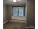 Bedroom with two windows with built in seat, carpeted floor, grey walls and white door at 602 W Council St, Salisbury, NC 28144