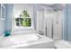 Bathroom with soaking tub, shower, and a window with curtains at 112 Sugar Thyme Ln, Mooresville, NC 28115