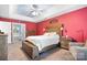 Bright bedroom with red walls, a wooden bed frame, and carpeted floors at 112 Sugar Thyme Ln, Mooresville, NC 28115