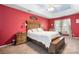 Red walls, wooden bed frame, carpeted floors, and ceiling fan at 112 Sugar Thyme Ln, Mooresville, NC 28115