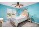 Light teal bedroom with a ceiling fan, wooden bed frame, and beach decor at 112 Sugar Thyme Ln, Mooresville, NC 28115