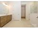 Spacious bathroom with double doors, dual sink vanity, and tiled flooring and walk-in closet at 1200 Meander Ln, Waxhaw, NC 28173