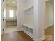 Mudroom entrance with built in bench, cubbies and hooks, and a view into the laundry room at 1200 Meander Ln, Waxhaw, NC 28173