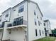 Modern townhouse with white siding, black window trim, and a balcony above the garage at 12110 Storm Ln # 49, Charlotte, NC 28277