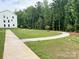 A view of the community with green space and mature trees surrounding the modern townhouses at 12110 Storm Ln # 49, Charlotte, NC 28277