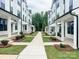 A view of townhouses lining the street, showcasing a manicured walkway and landscaping at 12110 Storm Ln # 49, Charlotte, NC 28277