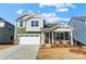 Charming two-story home with a two-car garage, stone accents, manicured lawn, and beautiful curb appeal at 2608 Tillman St, Monroe, NC 28112