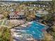Aerial view of community amenities including a pool, clubhouse, tennis courts, and bocce ball, surrounded by trees at 7095 Sunset Crater Pl, Lancaster, SC 29720