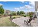 Lush backyard featuring a stone patio with seating, manicured lawn, and diverse plantings for a serene outdoor experience at 7095 Sunset Crater Pl, Lancaster, SC 29720