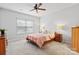 Cozy bedroom featuring a ceiling fan, plush carpet, large window and neutral-toned walls, creating a relaxing retreat at 7095 Sunset Crater Pl, Lancaster, SC 29720