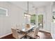 Bright dining room features a stylish light fixture, large windows, and hardwood floors with an open view to the backyard at 7095 Sunset Crater Pl, Lancaster, SC 29720