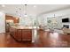 Open-concept kitchen with a large island, stainless steel appliances, and hardwood floors flowing into living area at 7095 Sunset Crater Pl, Lancaster, SC 29720