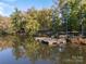 Beautiful lake view featuring a boat dock, calm water, and lush trees with fall colors at 7095 Sunset Crater Pl, Lancaster, SC 29720