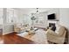 Bright living room features hardwood floors, a fireplace, neutral walls, and large windows allowing ample natural light at 7095 Sunset Crater Pl, Lancaster, SC 29720