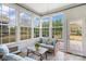 Bright sunroom with large windows, tile flooring, and wicker furniture creating a cozy indoor-outdoor living space at 7095 Sunset Crater Pl, Lancaster, SC 29720