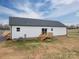 The back of the house has white vinyl siding, a dark roof, and a wooden deck at 9303 Reepsville Rd, Vale, NC 28168