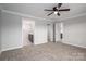 Spacious bedroom with multiple doorways, neutral carpet, and a ceiling fan for added comfort at 9303 Reepsville Rd, Vale, NC 28168