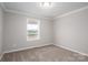 A bright bedroom with neutral walls, carpet floors, and a window view of a landscape at 9303 Reepsville Rd, Vale, NC 28168