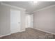 A bedroom with neutral walls, carpet floors, and multiple white doors at 9303 Reepsville Rd, Vale, NC 28168