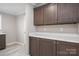 A kitchen featuring wooden cabinets, white countertop and flooring, and stainless-steel hardware at 9303 Reepsville Rd, Vale, NC 28168
