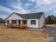Exterior view of a home featuring a covered porch, gray roof, gravel driveway and white siding at 9303 Reepsville Rd, Vale, NC 28168