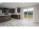 Spacious kitchen featuring modern appliances, dark wood cabinetry, and sliding glass doors to a wooden deck at 9303 Reepsville Rd, Vale, NC 28168