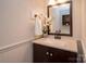 Elegant half bathroom with a vanity, decorative mirror, and modern fixtures at 10933 Hunter Trail Ln, Charlotte, NC 28226