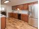 A spacious kitchen features stainless steel appliances, wood cabinets, granite counters, and hardwood floors at 10933 Hunter Trail Ln, Charlotte, NC 28226