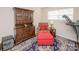 Comfortable living room with a cabinet, armchair, ottoman, and a treadmill by the window at 10933 Hunter Trail Ln, Charlotte, NC 28226