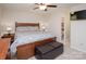 Relaxing bedroom with ceiling fan, wood furniture, and nearby bathroom at 10933 Hunter Trail Ln, Charlotte, NC 28226