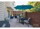 Charming patio area with brick privacy wall, seating, umbrella, and grilling area at 10933 Hunter Trail Ln, Charlotte, NC 28226