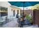 Cozy brick patio featuring outdoor seating, a dining table, and a vibrant blue umbrella at 10933 Hunter Trail Ln, Charlotte, NC 28226