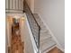 Carpeted staircase with decorative wrought iron railing and wood-look flooring in entry at 10933 Hunter Trail Ln, Charlotte, NC 28226