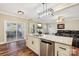 Kitchen island with sink and dishwasher overlooking the living room and backyard access at 4225 Cheshire Glen Dr, Monroe, NC 28110