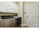Well-equipped laundry room with modern washer and dryer units and white cabinetry for storage at 4225 Cheshire Glen Dr, Monroe, NC 28110