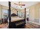 Main bedroom featuring a four-poster bed, dark wood furniture, and a sitting bench at 4225 Cheshire Glen Dr, Monroe, NC 28110