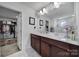 Elegant bathroom features double sinks, dark wood cabinetry, a large mirror, and a glass-enclosed shower, providing a luxurious feel at 535 Red Wolf Ln, Clover, SC 29710