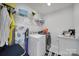 Well-lit laundry room features modern appliances, wire rack shelving, an ironing board, and stylish decor at 535 Red Wolf Ln, Clover, SC 29710