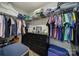 Organized walk-in closet with ample hanging space and shelving above a dark dresser for storing clothes and linens at 535 Red Wolf Ln, Clover, SC 29710