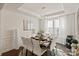 Elegant dining room with seating for eight, modern chandelier, and large windows with sheer curtains at 535 Red Wolf Ln, Lake Wylie, SC 29710