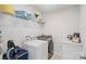 Functional laundry room featuring modern washer and dryer units and ample storage space with laundry supplies at 535 Red Wolf Ln, Lake Wylie, SC 29710