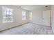 Bright bedroom with gray carpeting, large windows, and an interior door at 165 Smokey Way, Statesville, NC 28625