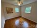 Bedroom with hardwood floors, base trim, two windows, and a ceiling fan at 1727 Hartford Dr, Gastonia, NC 28052