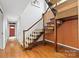 Staircase with wood railing and brick accent wall at 423 Whitestone Rd, Charlotte, NC 28270