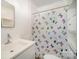 Clean bathroom with a white vanity, a shower with a butterfly patterned curtain, and bright lighting at 802 E Harrison Ave, Gastonia, NC 28054