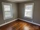 Neutral bedroom with hardwood floors, a ceiling fan, and bright windows offering a comfortable retreat at 802 E Harrison Ave, Gastonia, NC 28054