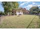 Quaint home with a spacious yard, surrounded by mature trees and a chain-link fence at 802 E Harrison Ave, Gastonia, NC 28054